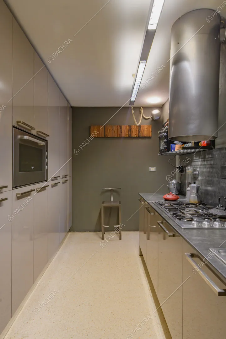 Grande cucina a parete con fornelli a gas e parete verde scuro
