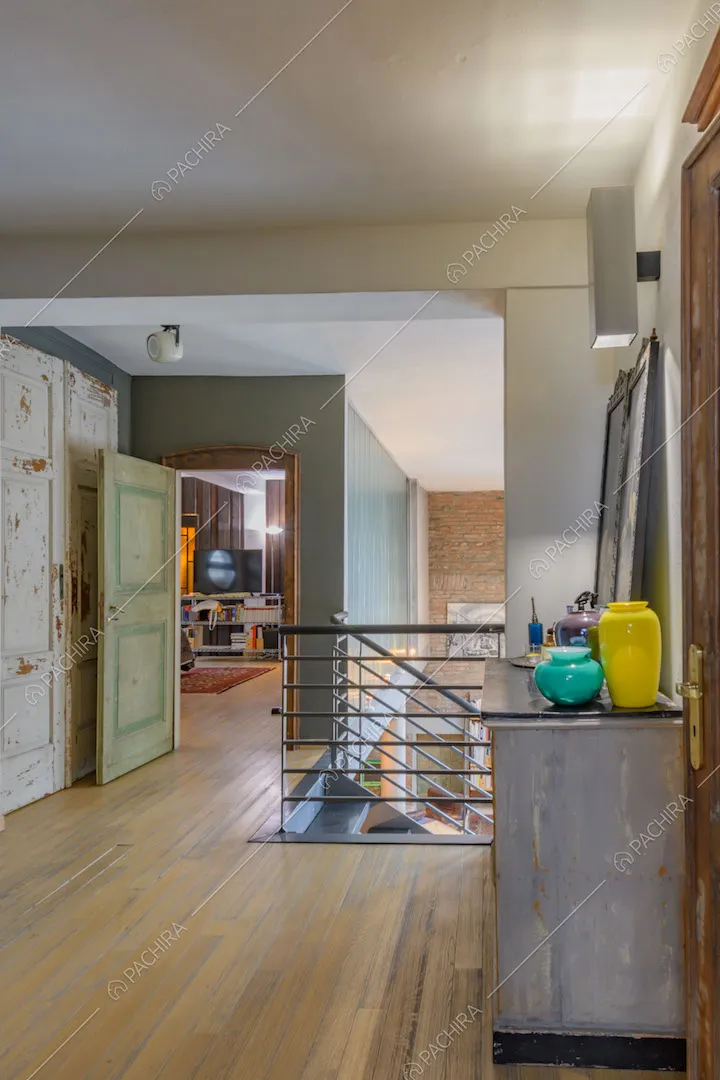 Atrio con pavimento in parquet, scale e scorcio sulla camera da letto