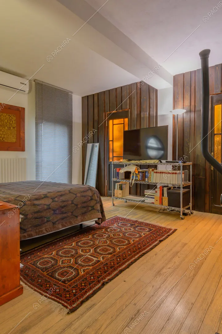 Camera da letto con pavimento in parquet e pareti in legno scuro