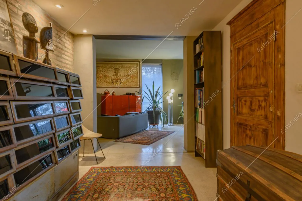 Mobili di design e parete in mattoni nella sala con vista sul divano nero