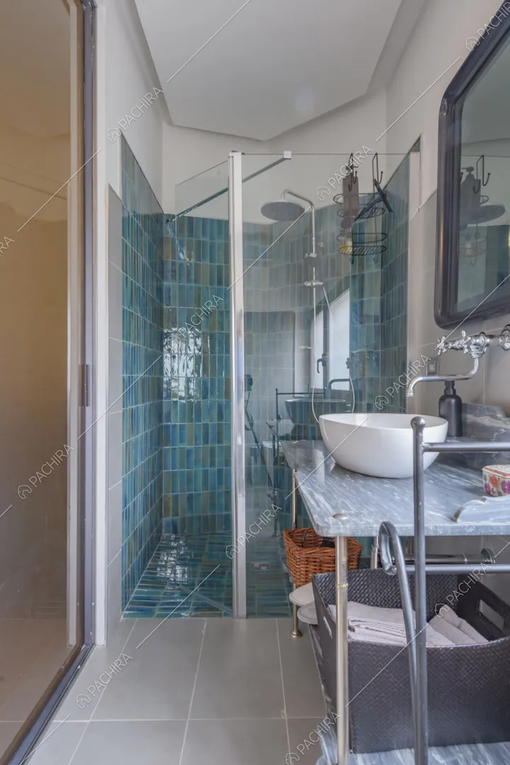 Bagno della camera da letto con piastrelle azzurre nel box doccia