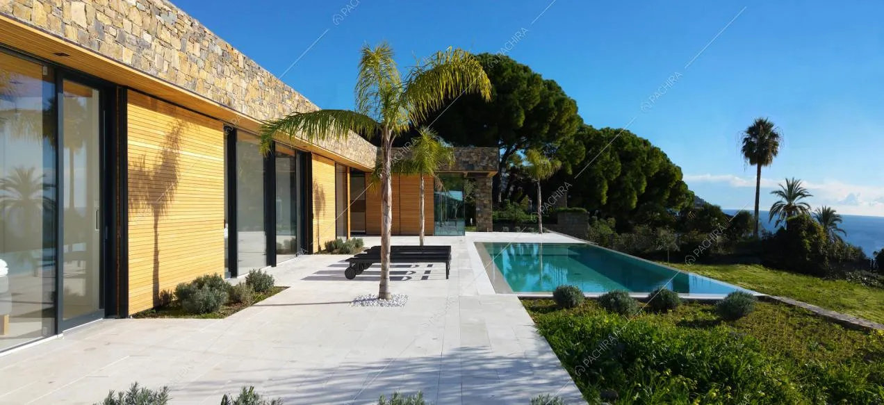 Terrazza con piscina a sfioro, palme, macchia mediterranea e vista sul mare