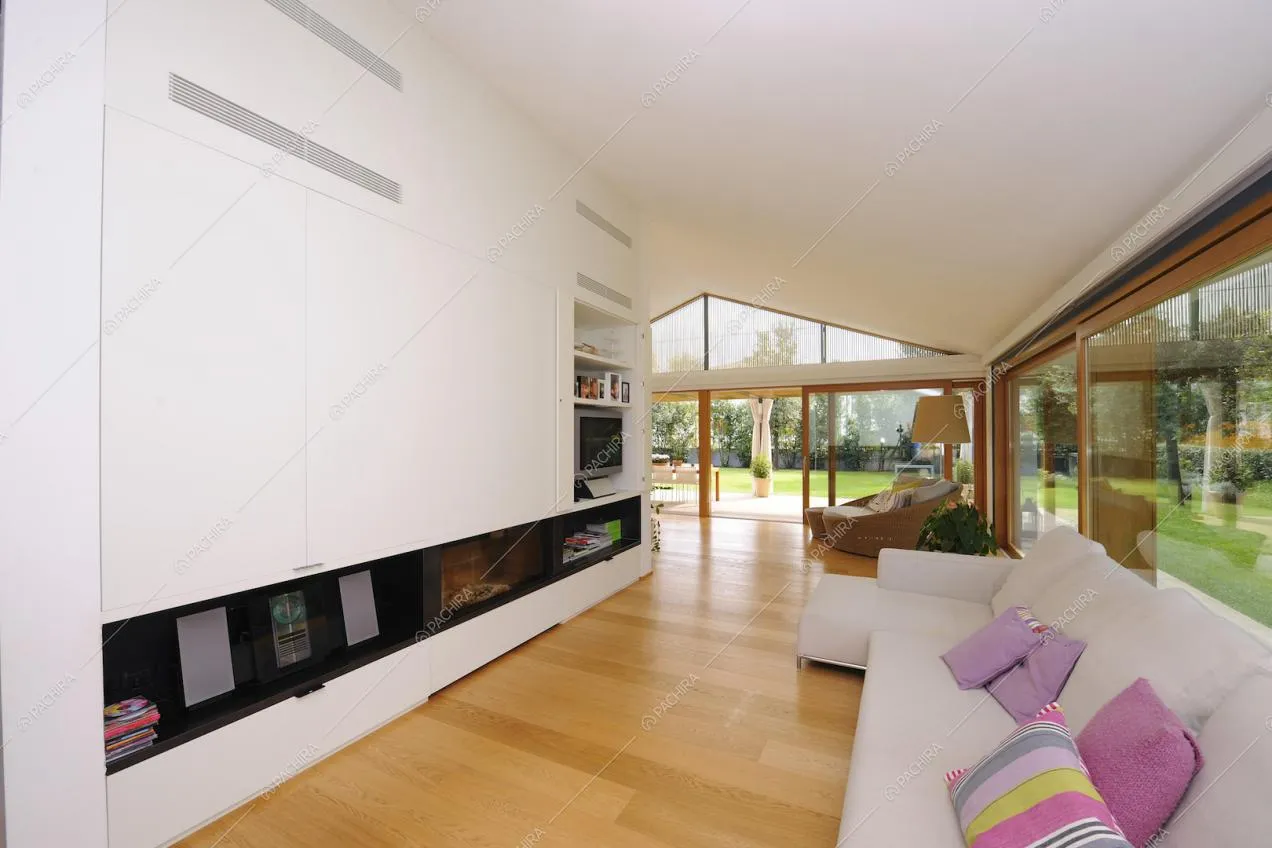 Sala minimal con ampie vetrate sul giardino