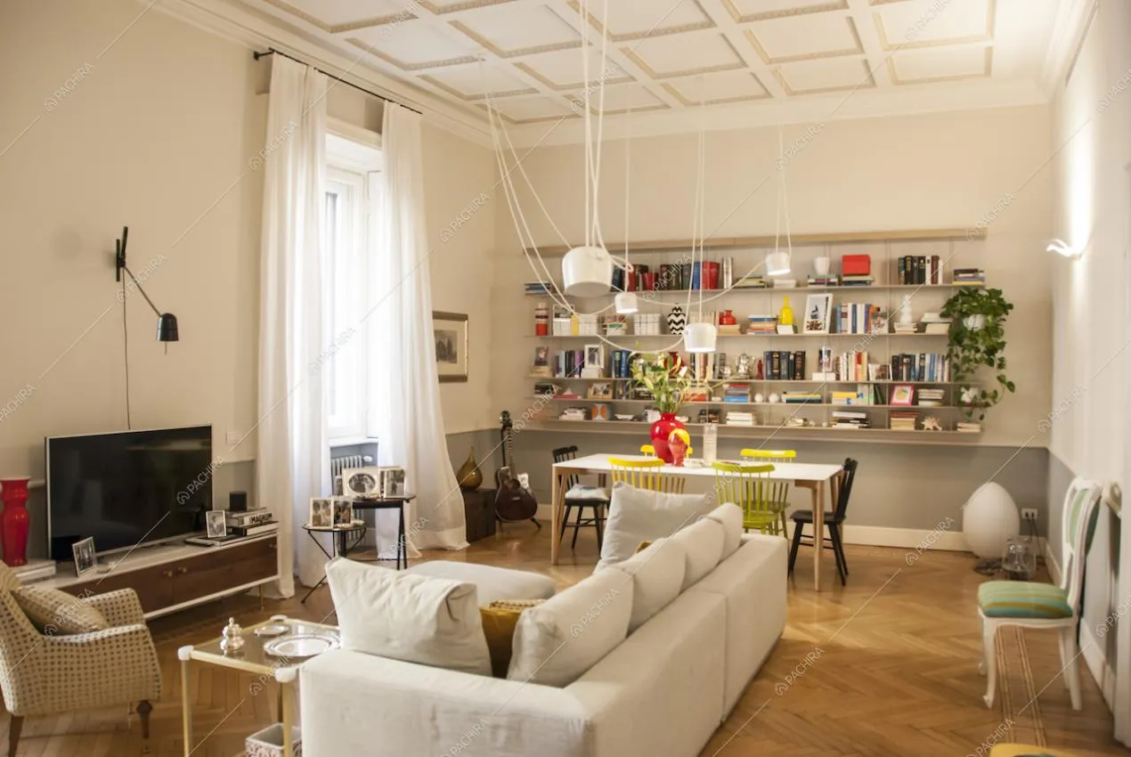 La sala dell'appartamento Carvi a Milano con pavimento in parquet e divano bianco