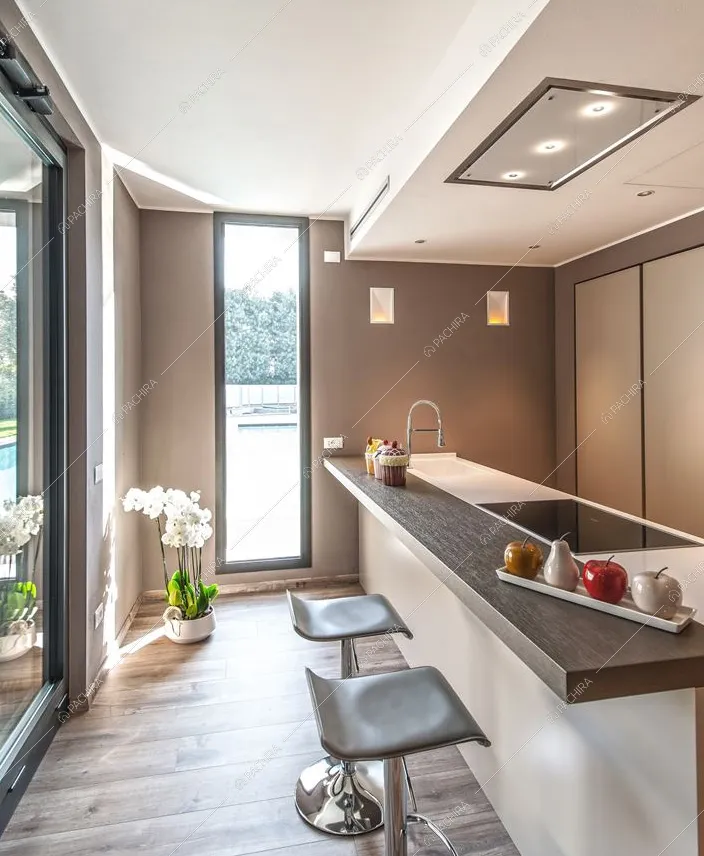 Cucina a penisola e vetrate in questa villa moderna in Provincia di Brescia