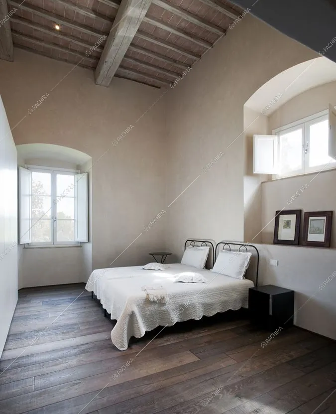 Camera da letto con pavimento in parquet e travi in legno