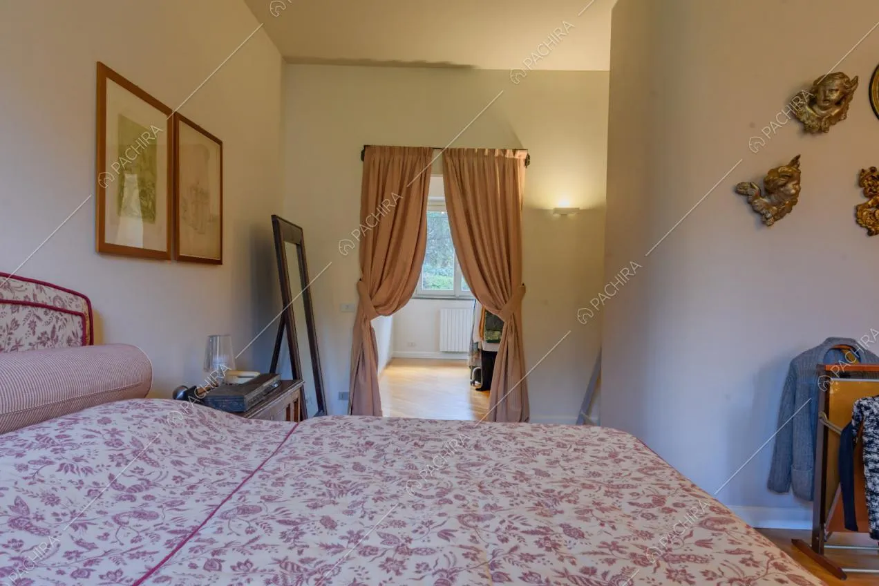 Camera da letto matrimoniale con pareti bianche e pavimento in parquet