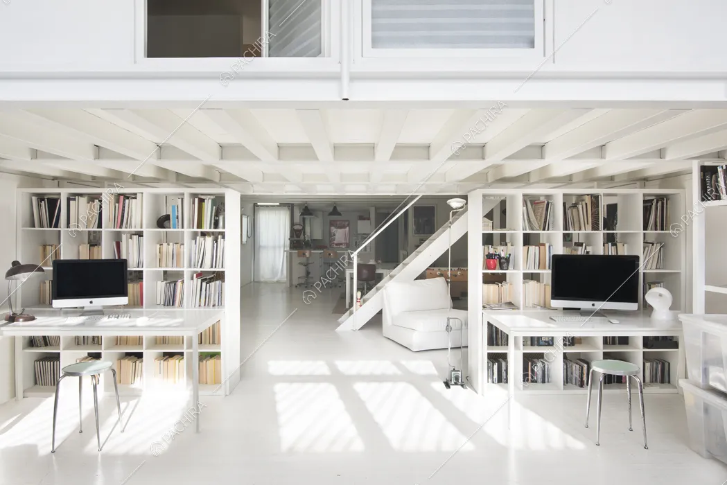 Studio con due scrivanie, librerie e vista sulla cucina