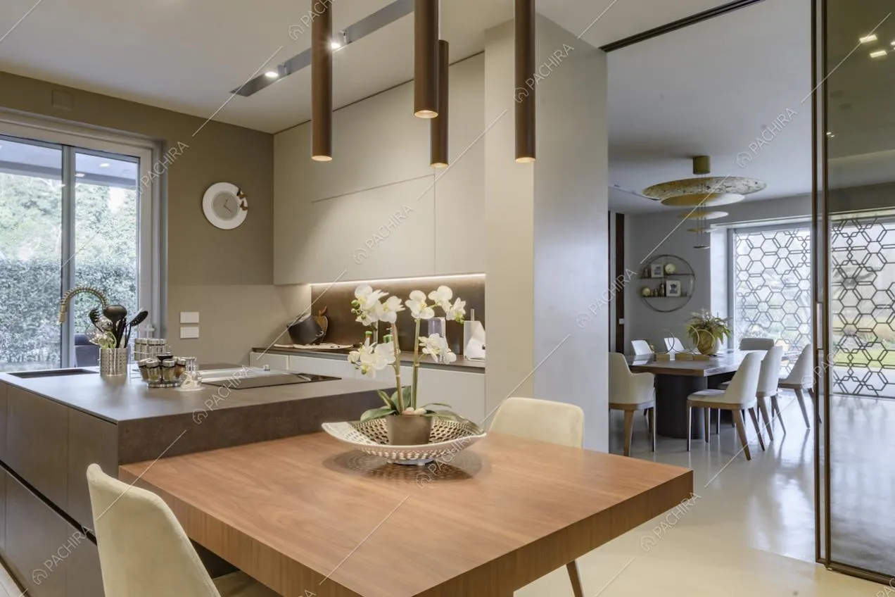 Cucina con isola e lampade di design con vista sul tavolo da pranzo nella sala