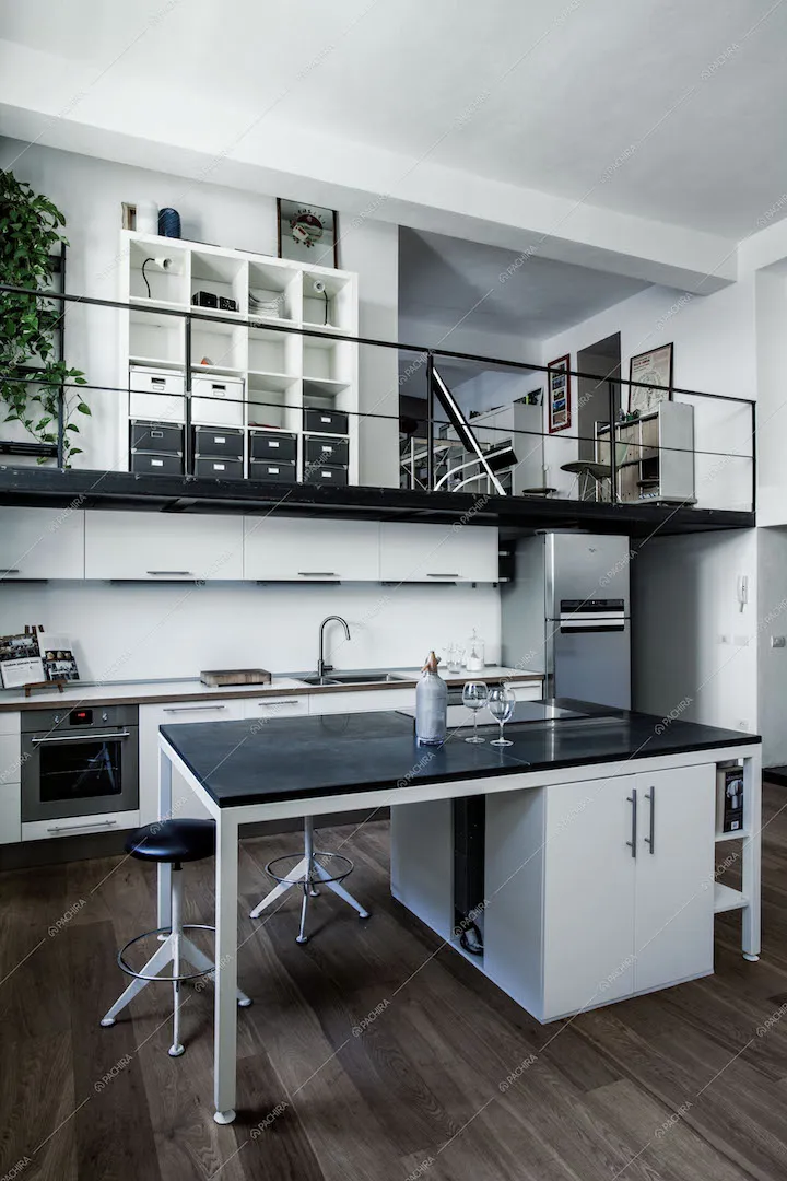 Cucina con isola e sgabelli, soppalco in metallo nero