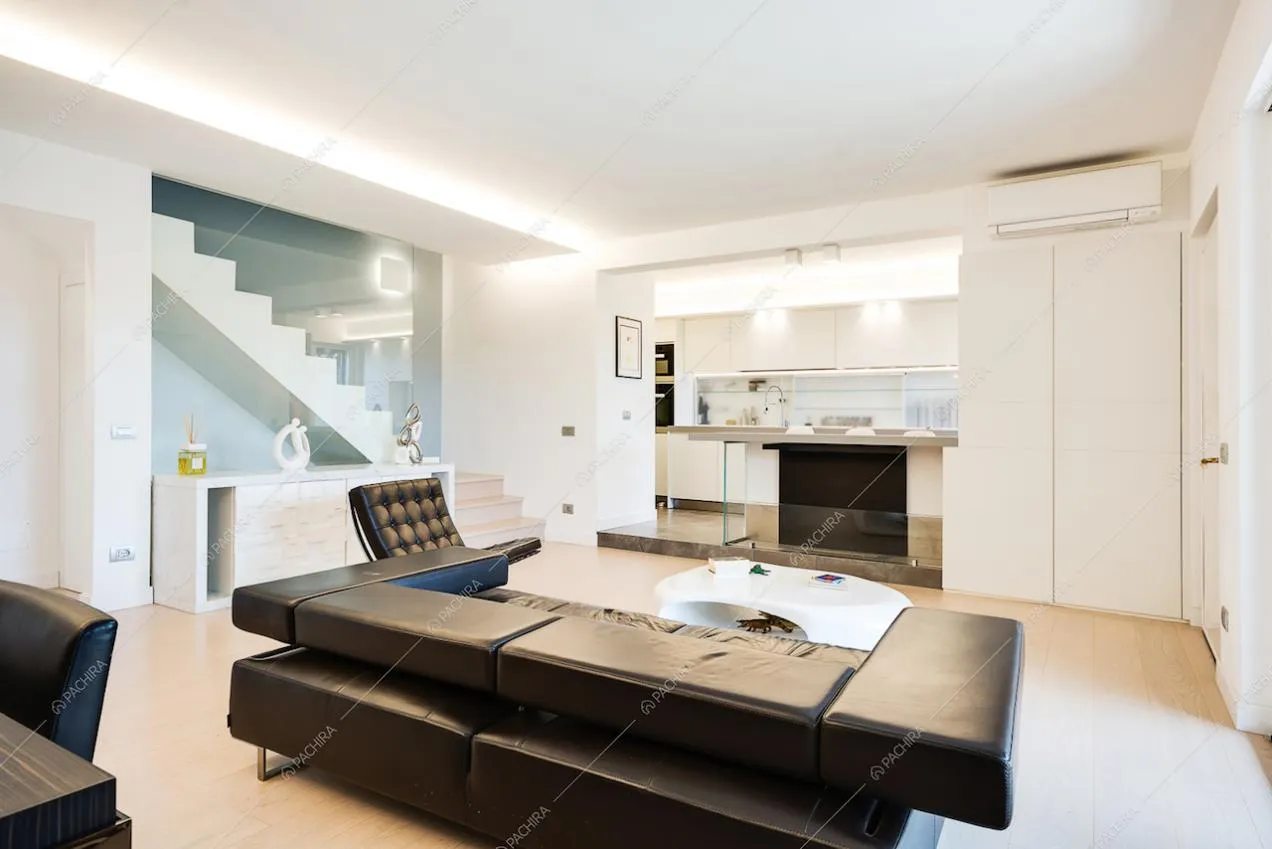 Zona living con divano e poltrona neri in pelle