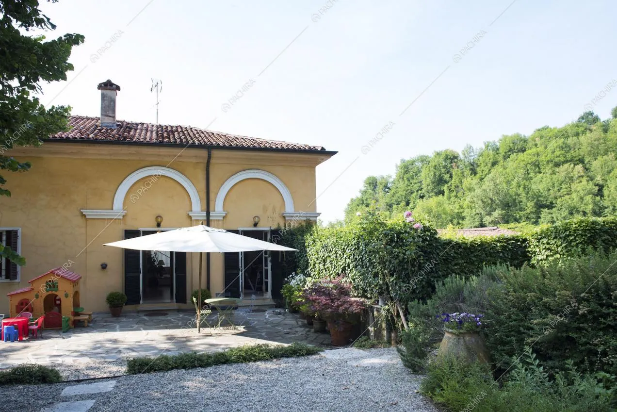 Villa dall'esterno color senape con ombrellone