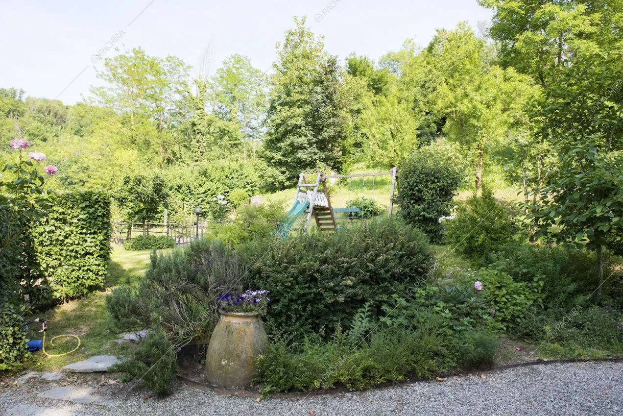 Scivolo e altalene immersi nel verde del giardino