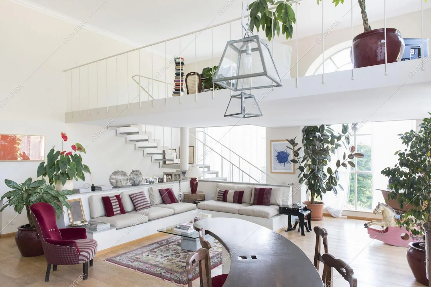 Zona living con divano bianco e soppalco