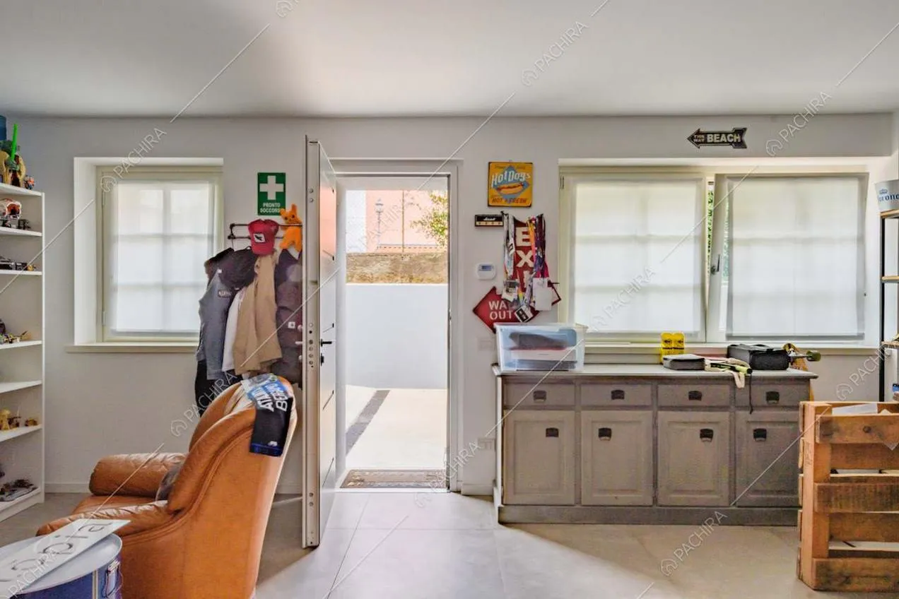 Pavimento in grandi piastrelle grigie nello studio con poltrone in pelle