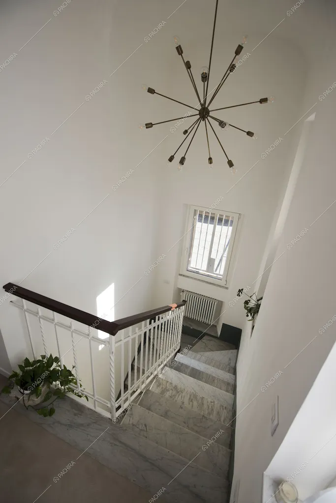 Inquadratura delle scale in marmo dall'alto e lampadario di design