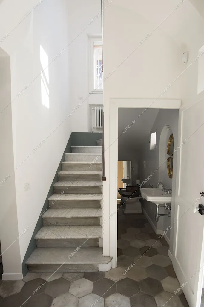 Scale e bagno nel sottoscala con pavimento a cementine esagonali grigie