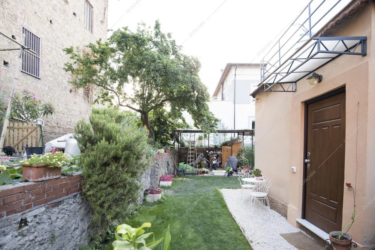 Giardino con veranda e piccolo tavolo in metallo bianco