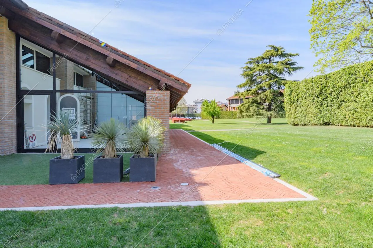 Luminosa veranda con vetrate e colonne in mattoncini rossi