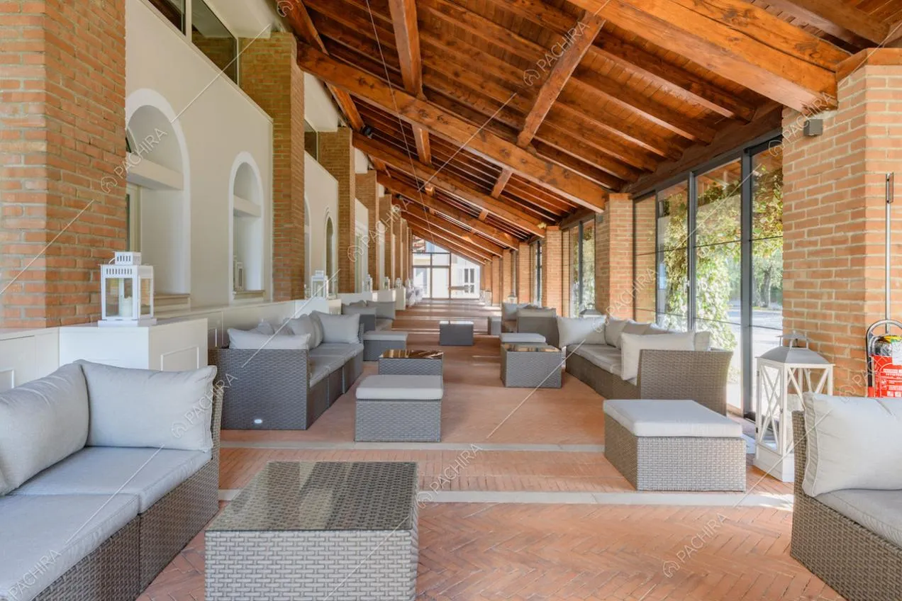 Grande vetrata con colonne in mattoncini rossi e soffitto in travi in legno a vista