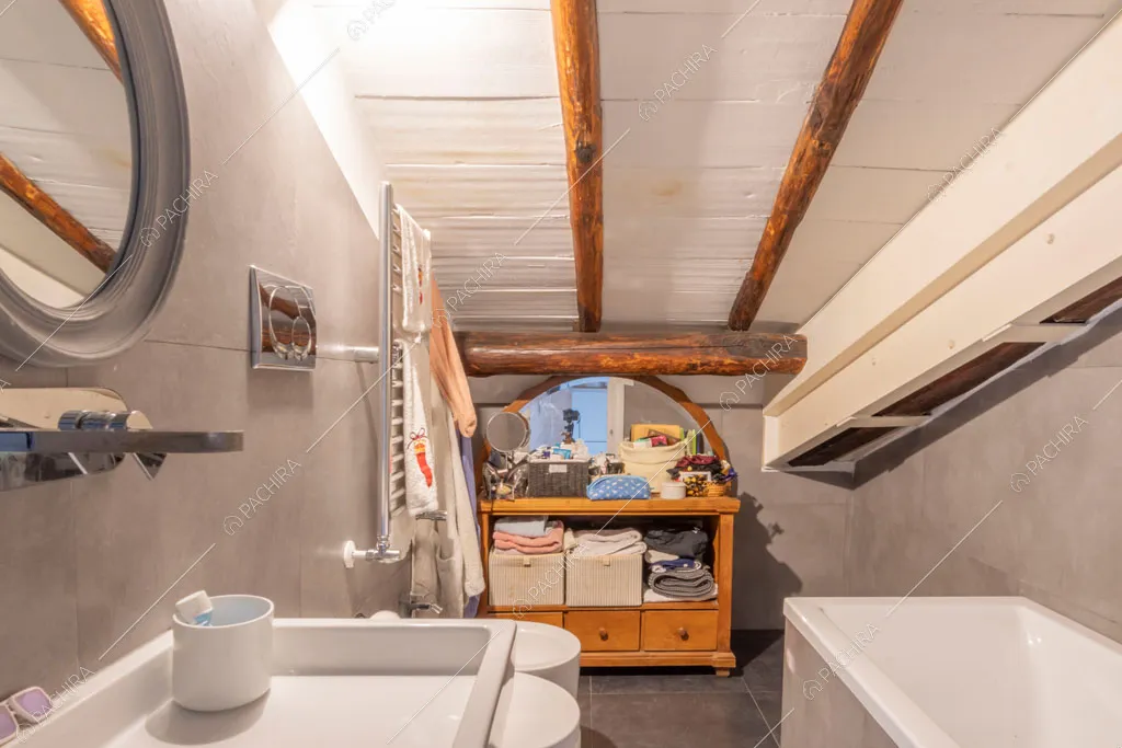 Bagno con travi in legno a vista sul soffitto nell'appartamento Uru, location in stile moderno a Roma