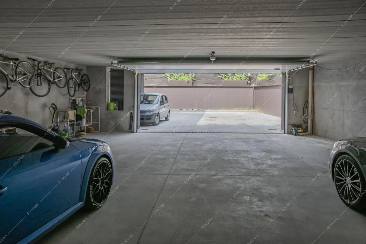 Grande garage con automobili e biciclette appese