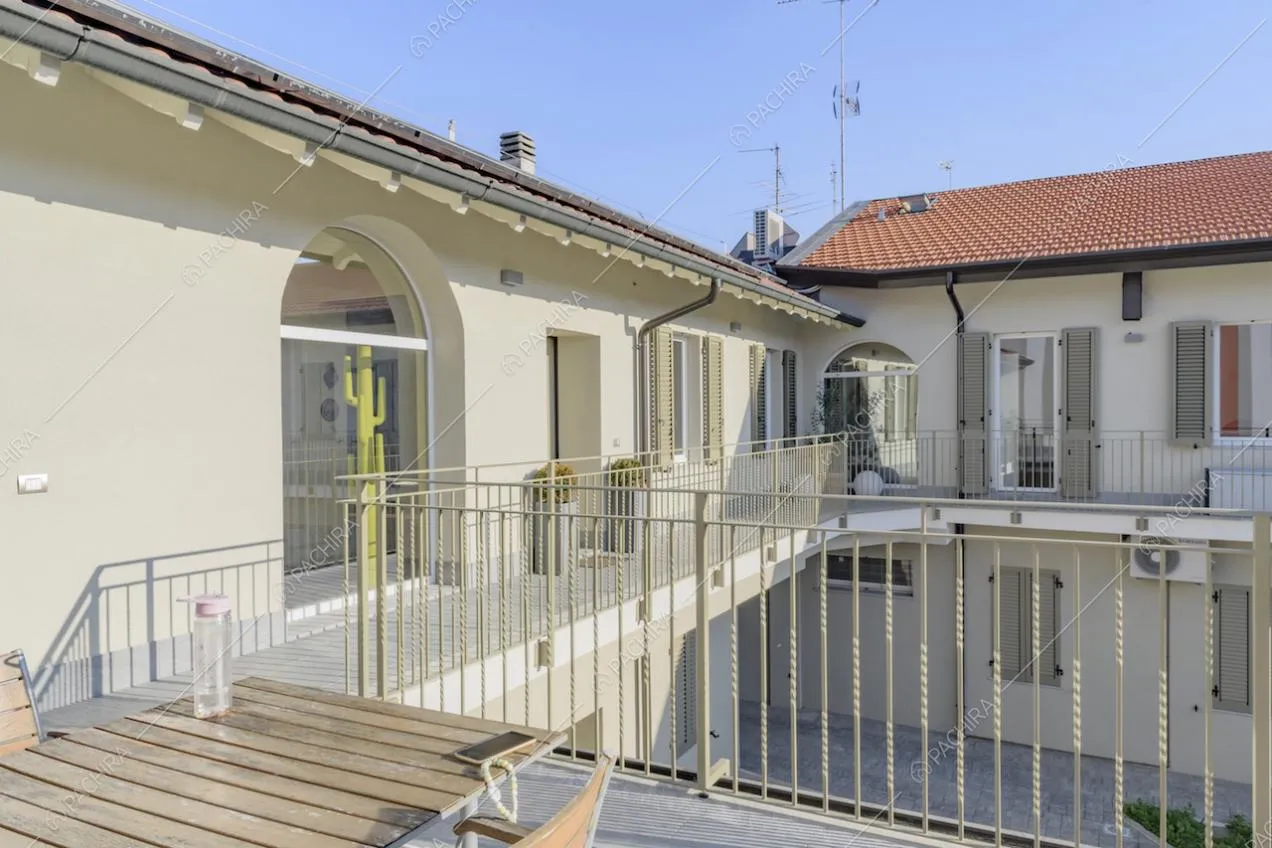 Terrazza con tavolo in legno da esterno sul ballatoio