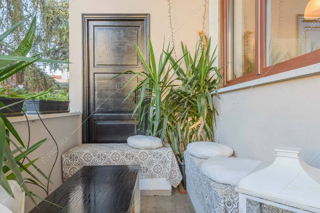 Balcone con porta con boiserie nera, panca e vista sugli esterni bianchi