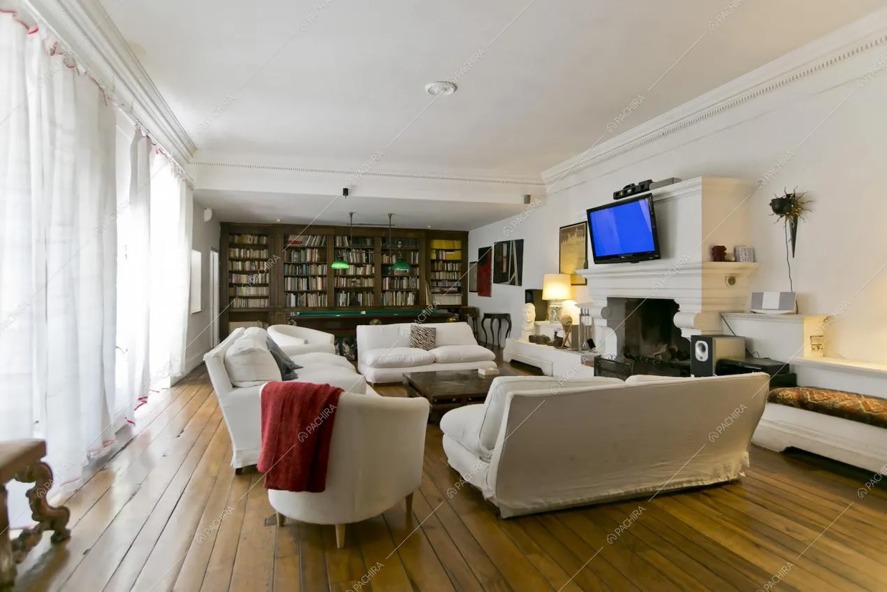 Salotto con pavimento in parquet e libreria a tutta parete