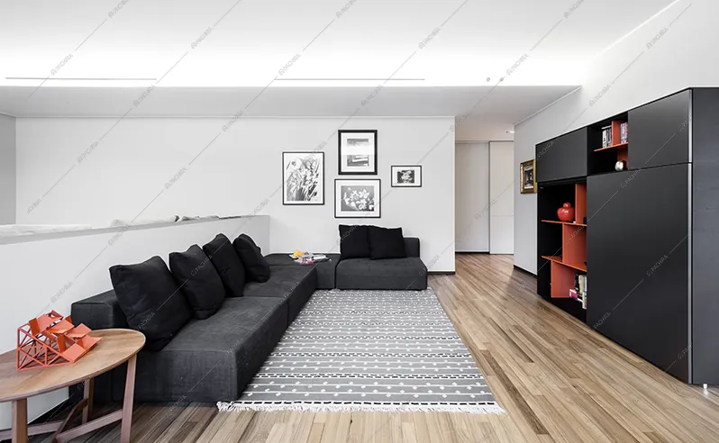 Zona living con divano e libreria neri, tavolino in legno