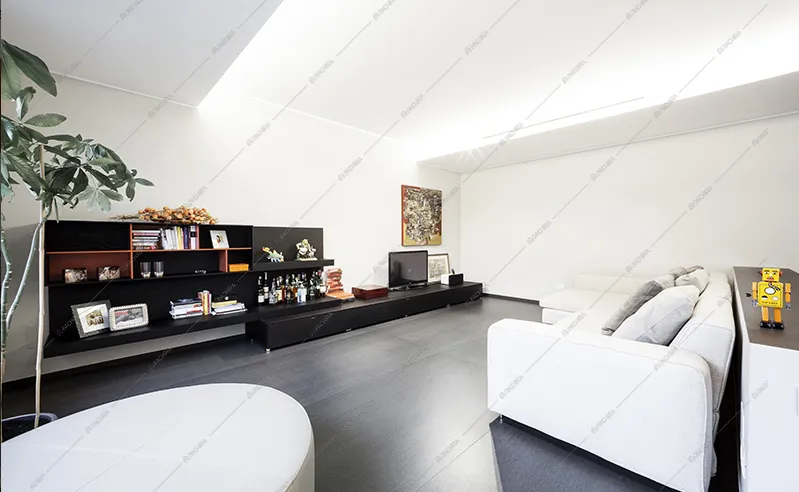 Zona living rialzata con divano bianco e libreria bassa nera