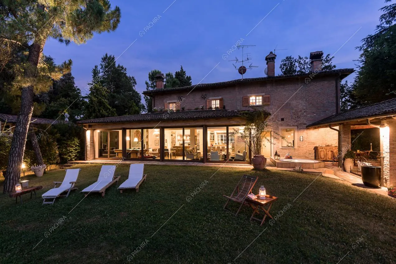 Giardino privato della location con lettini bianchi e vista sugli interni attraverso le vetrate