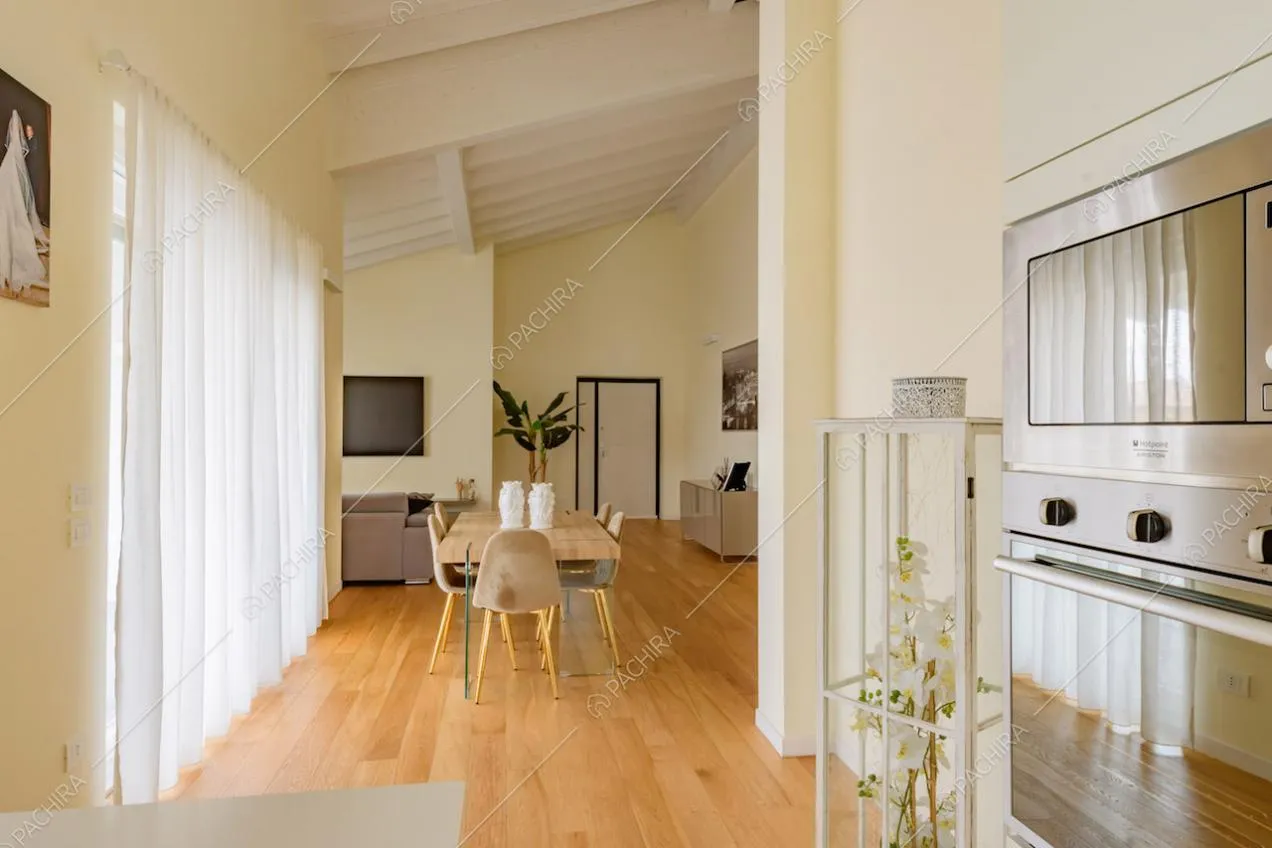 Tavolo da pranzo in legno nella zona living con vetrate e pavimento in parquet