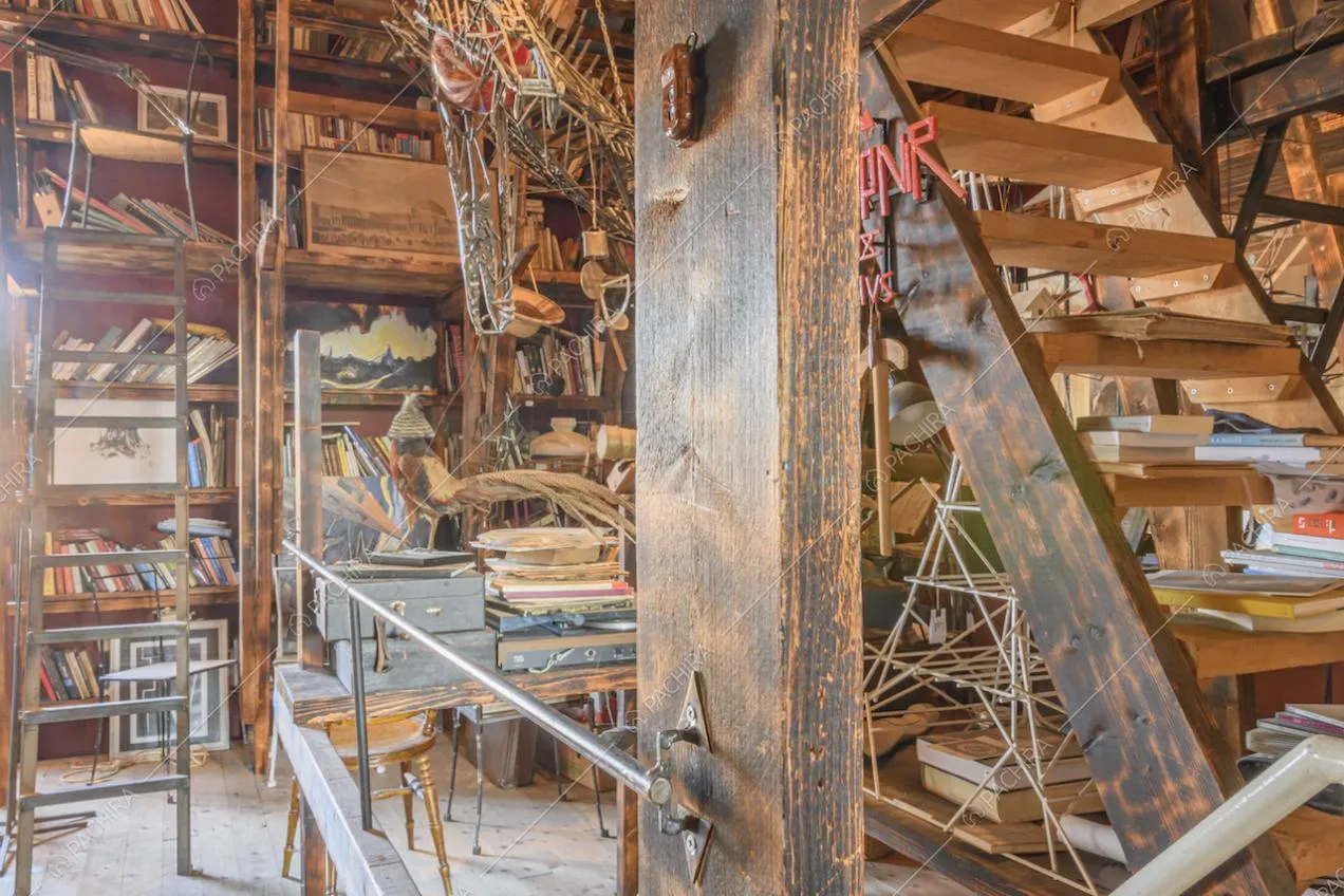 Scale a pioli e scaffalature in legno con libri e oggetti