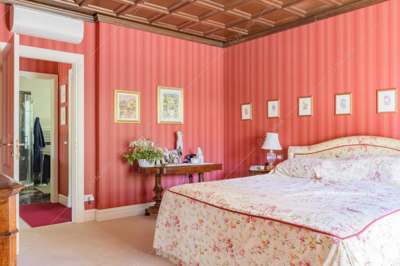 Soffitto a cassettoni e carta da parati rossa nella camera da letto