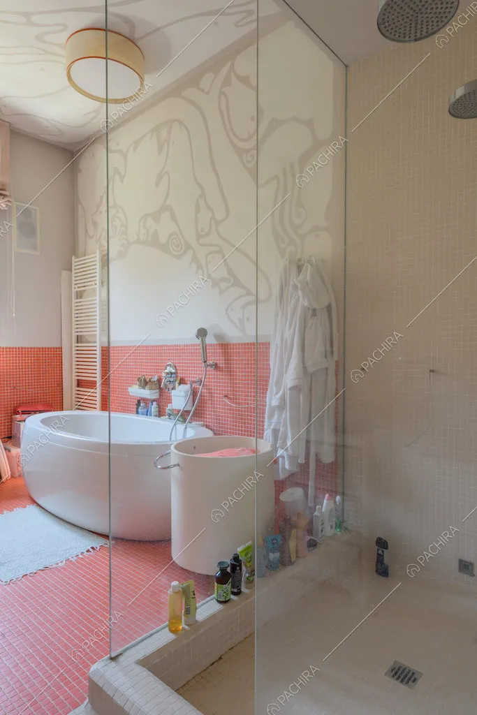 Ampio bagno con box doccia, vasca e carta da parati