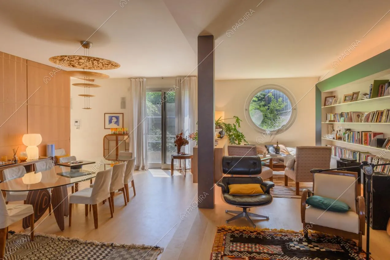 Zona living con pavimento in parquet, colonna e libreria