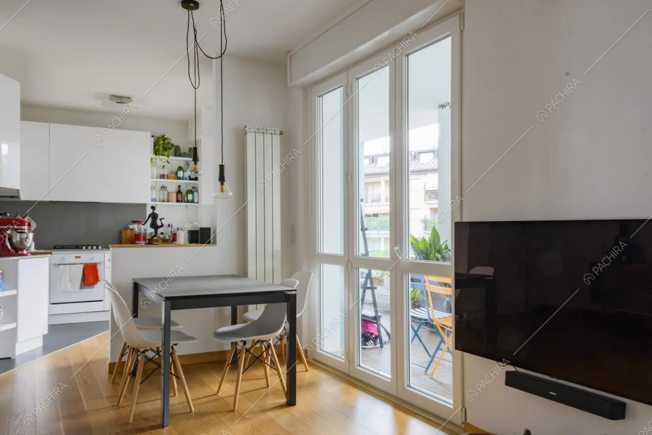 Tavolo da pranzo con sedie di design e cucina a vista