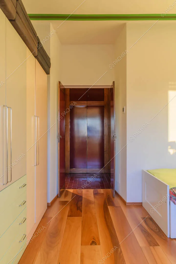 Camera da letto con pavimento in parquet e pareti bianche