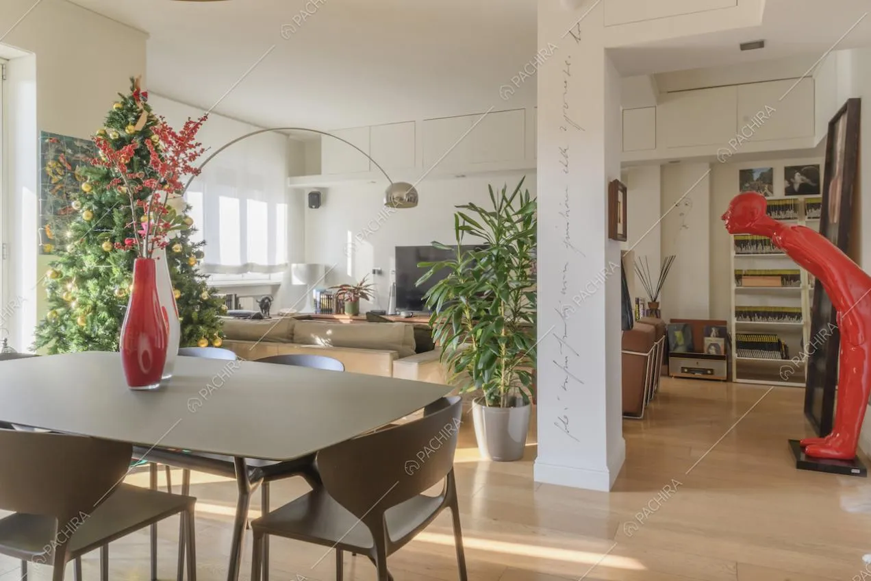 Zona living con colonna bianca e pavimenti in parquet