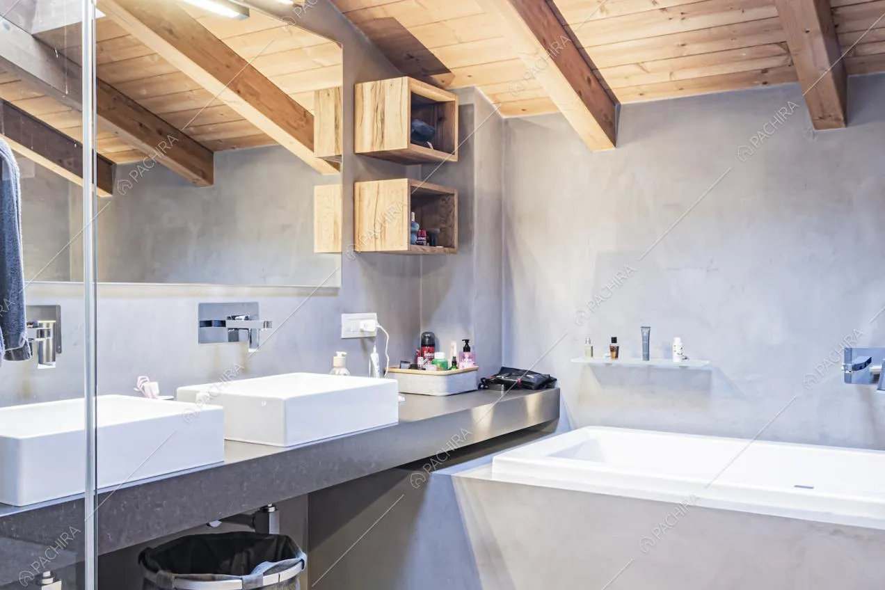 Vasca da bagno, lavandini moderni, specchio e travi in legno