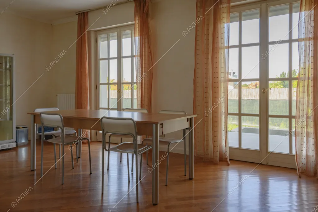 Zona pranzo con tavolo e grandi porte finestre