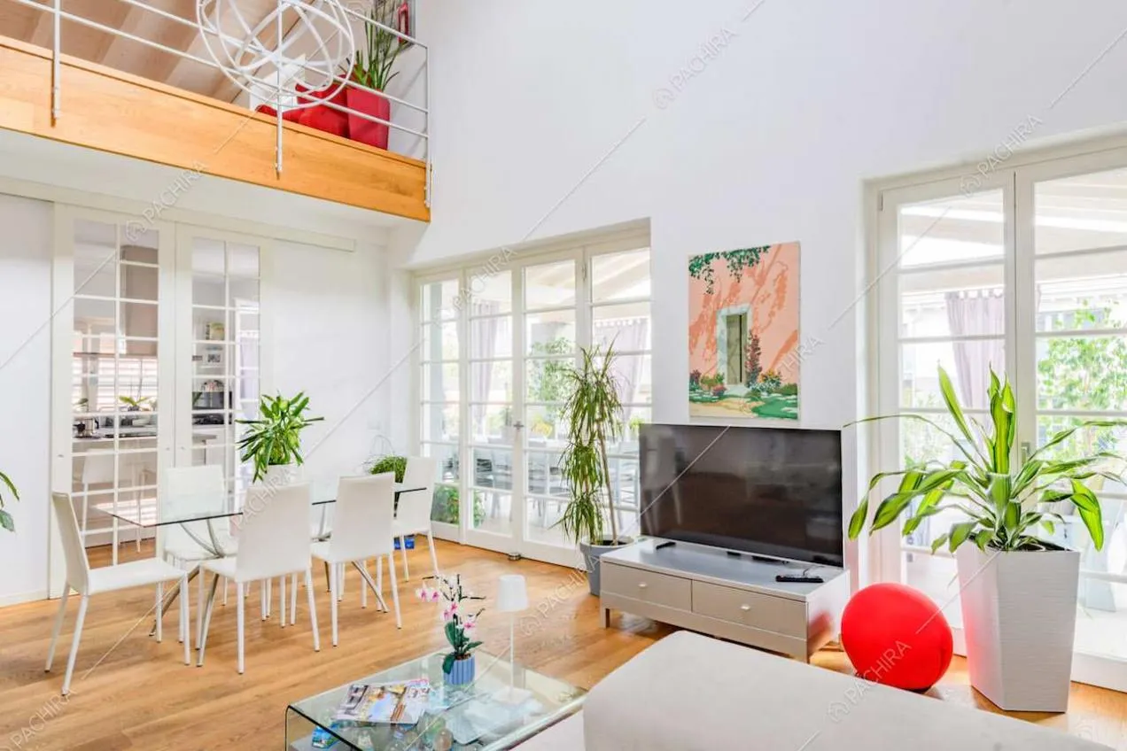 Dalla zona living con pavimento in parquet vista sul soppalco