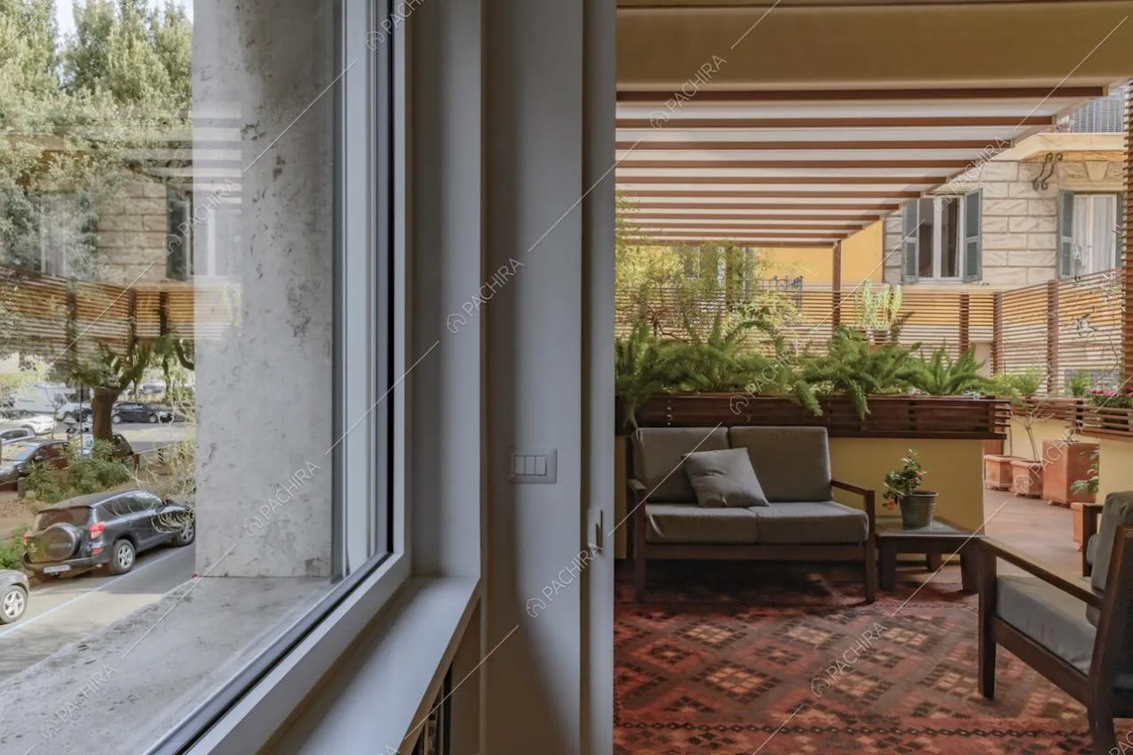 Terrazza con veranda e salotto da esterni con pavimentazione in parquet