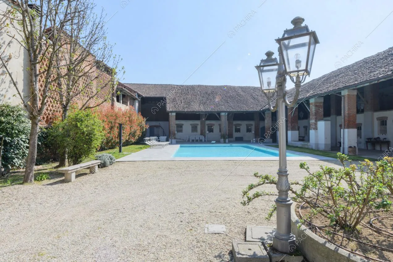 Lampione nel grande cortile con pavimentazione in ciottoli e piscina