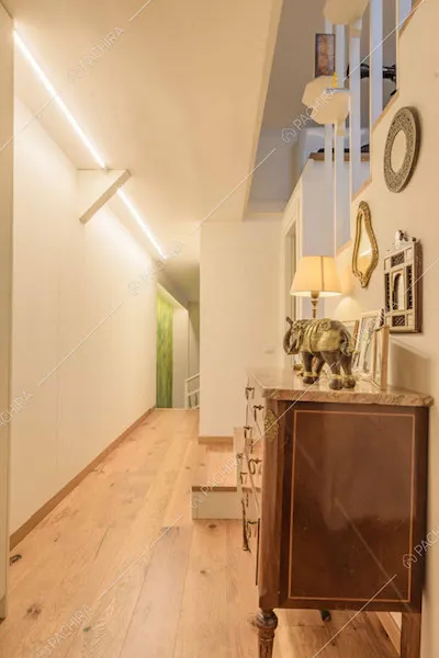 Corridoio con pareti bianche, pavimento in parquet e scale