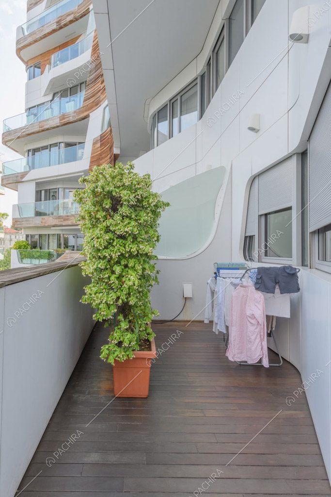 Terrazza con pavimentazione in parquet e vista sugli esterni bianchi del palazzo