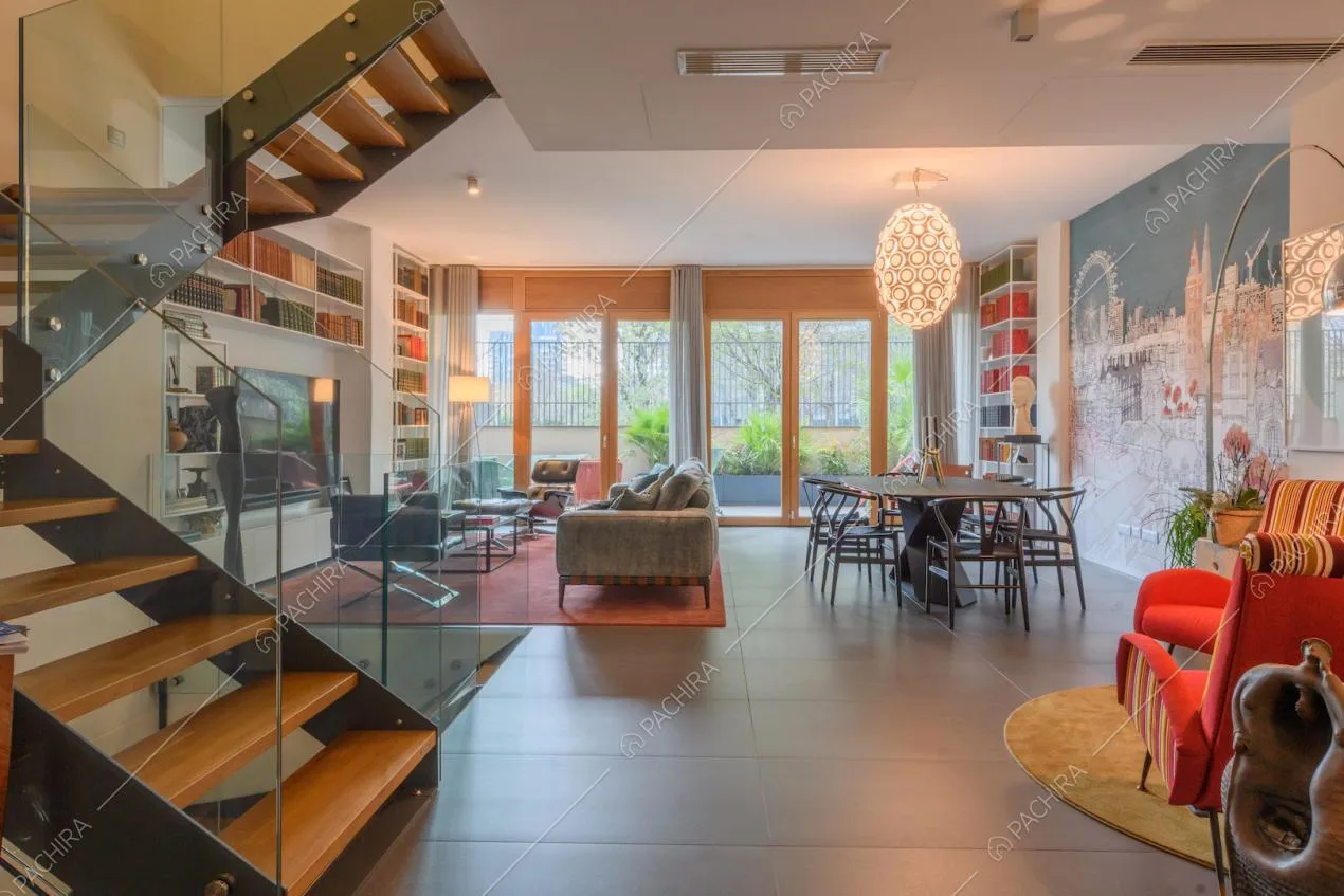 Luminosa zona living con pavimento in piastrelle nere e porte-finestre dagli infissi in legno