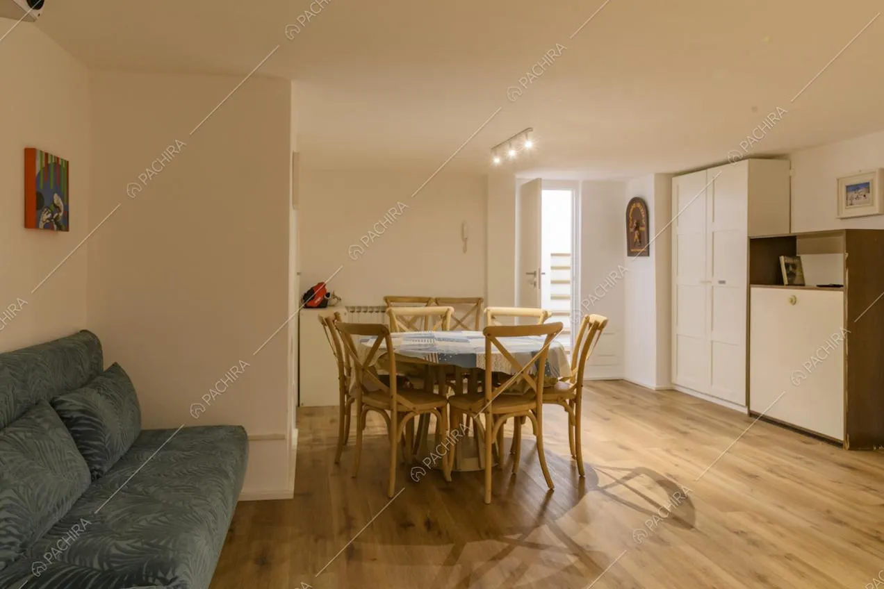 Tavolo da pranzo rotondo con sedie in legno e armadio bianco