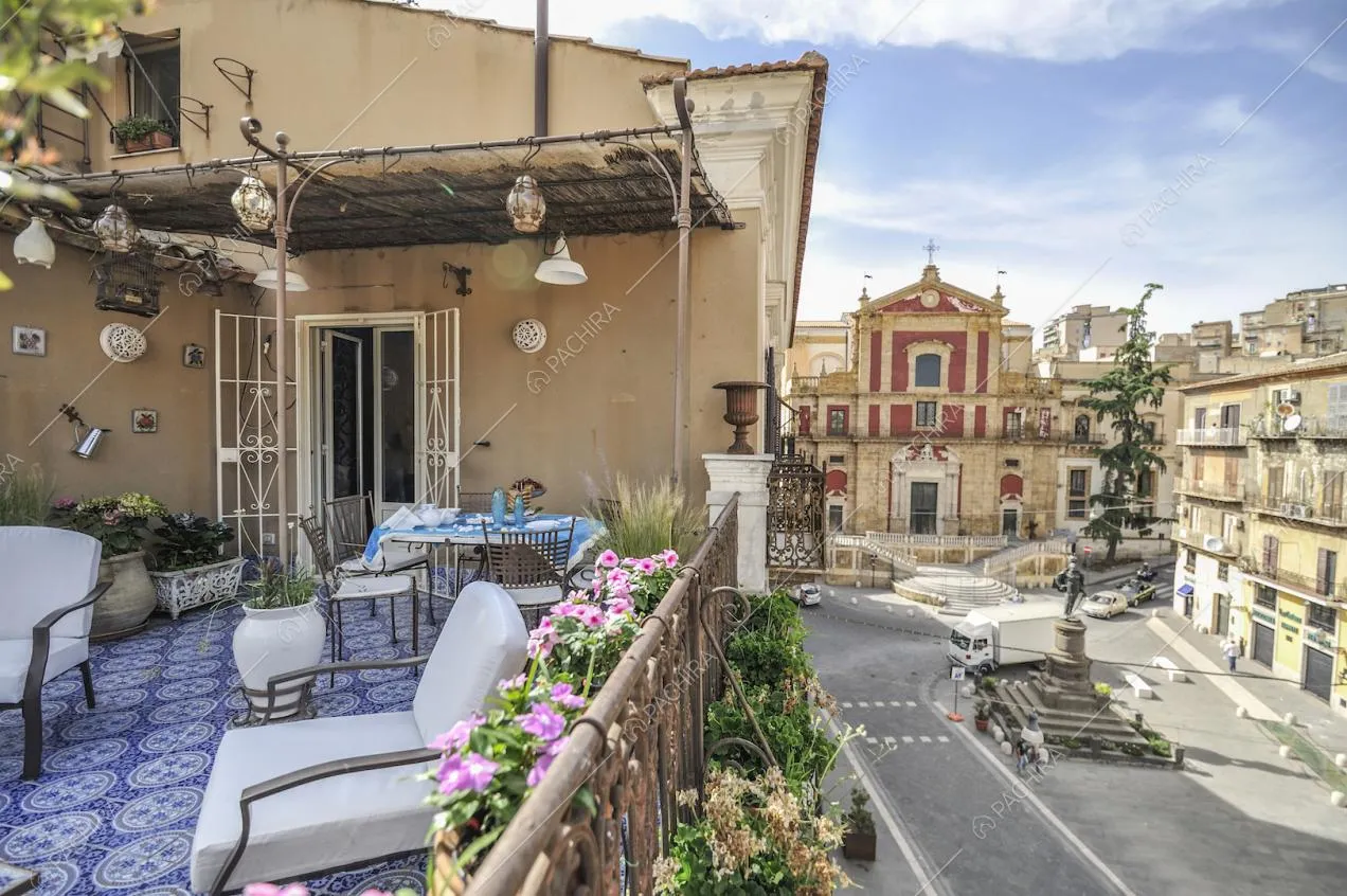 Terrazza con tavolo, sedie in ferro, piccolo bersò e ringhiera in ferro